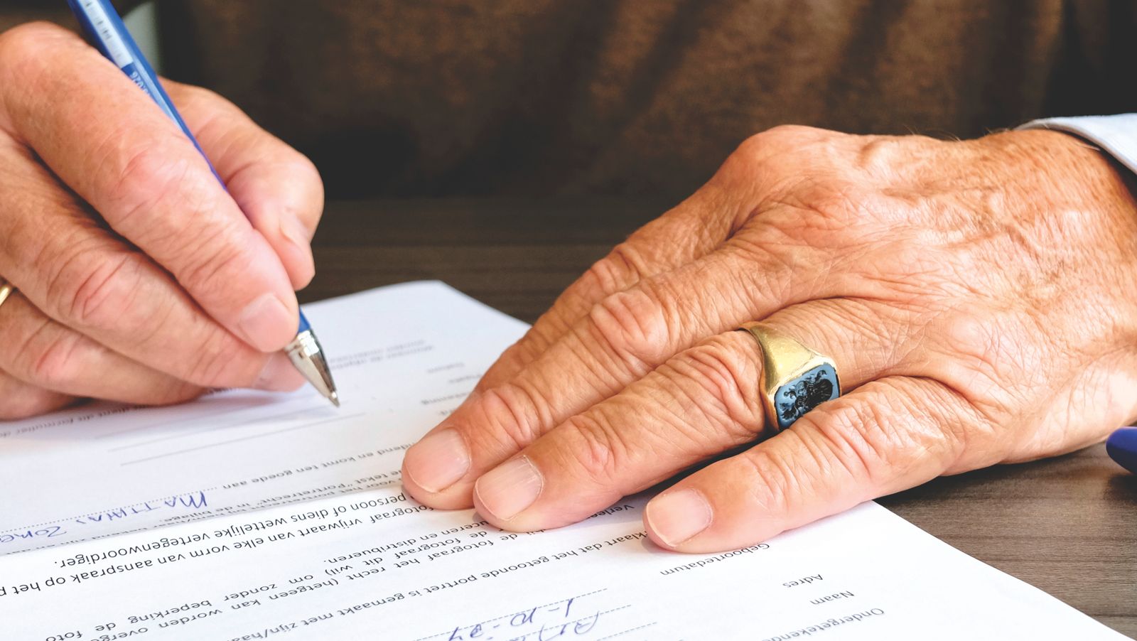 Due persone firmano un documento su una scrivania